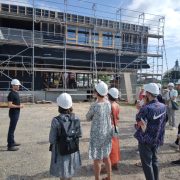 Groupe de personnes devant un bâtiment en construction. Visite de chantier du groupe scolaire à Rountzenheim-Auenheim