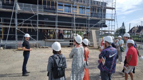 Groupe de personnes devant un bâtiment en construction. Visite de chantier du groupe scolaire à Rountzenheim-Auenheim