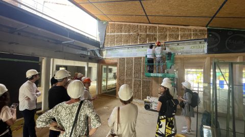 Visite de chantier à Rountzenheim-Auenheim : des personnes observent un ouvrier sur une échelle au site de construction.